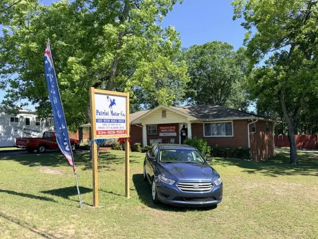 Brick building with car and sign