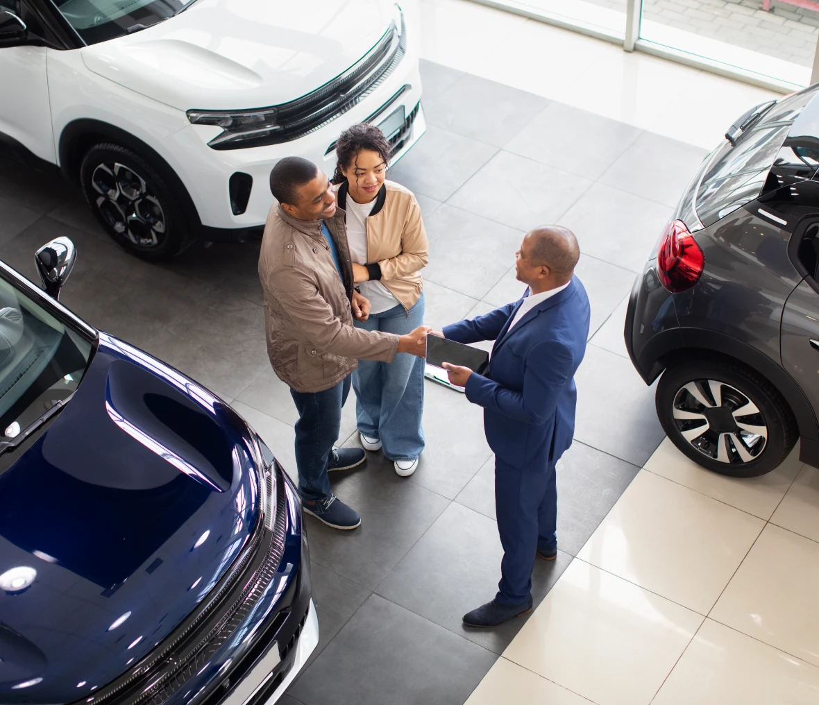 Salesman with couple at car showroom